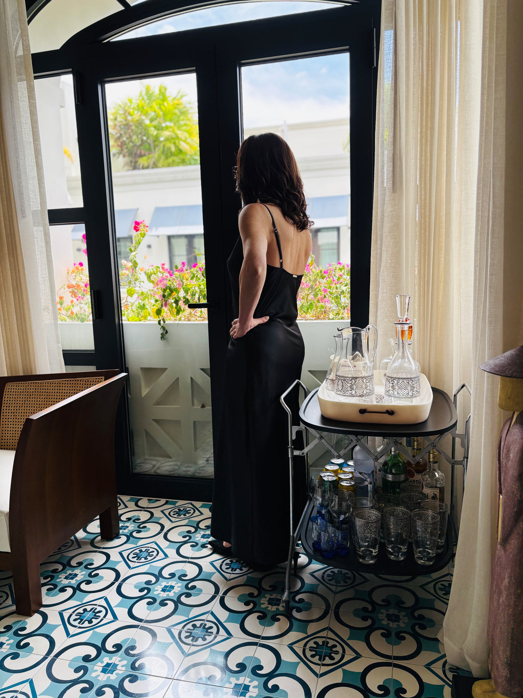 Back view of black strappy maxi dress highlighting open back design and refined fit