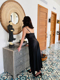 Strappy black maxi dress styled with minimal straps and flowing silhouette, front elegant look