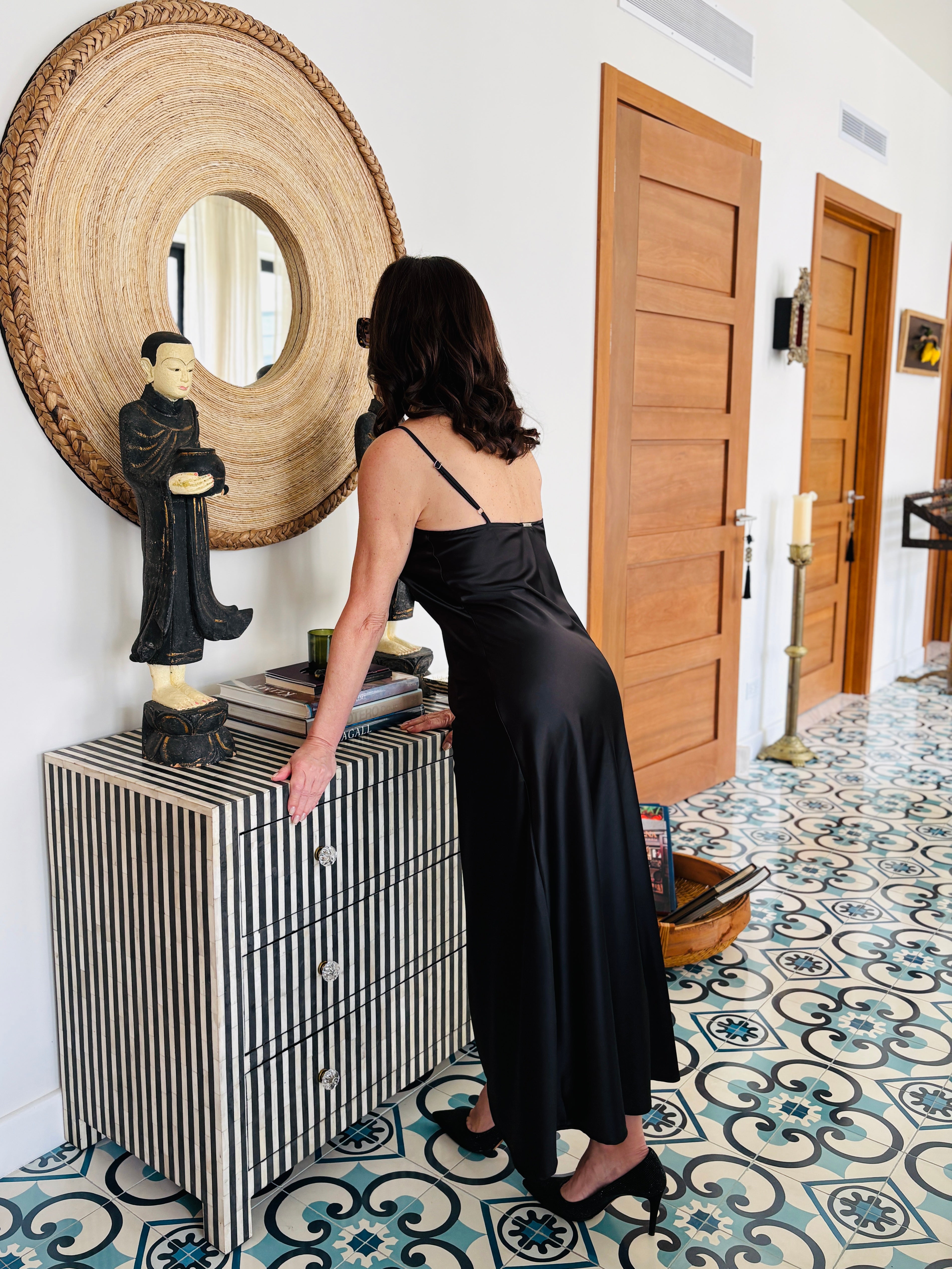 Strappy black maxi dress styled with minimal straps and flowing silhouette, front elegant look