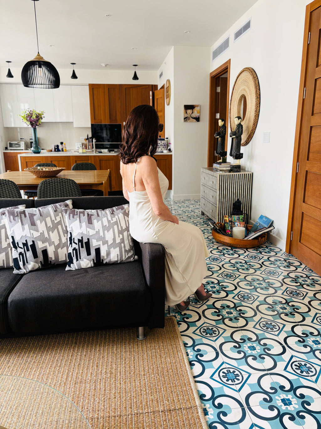 Back view of white strappy maxi dress in seated pose highlighting sleek fit and soft drape