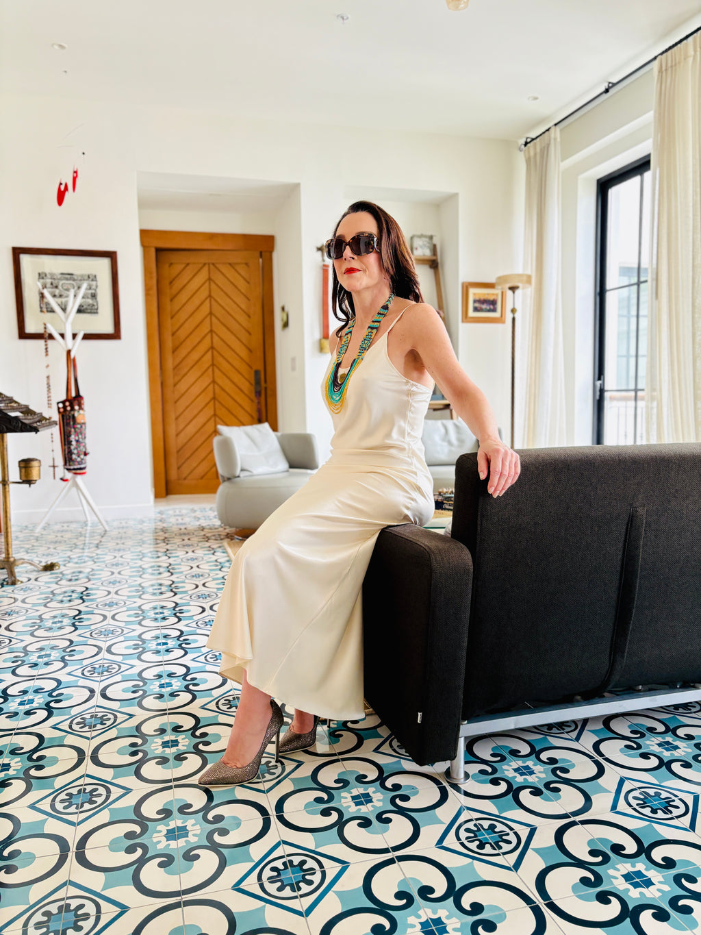 White strappy maxi dress styled in a seated position, reflecting refined and timeless elegance