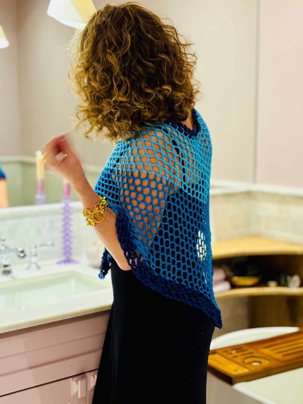 Close-up of crochet texture in blue poncho