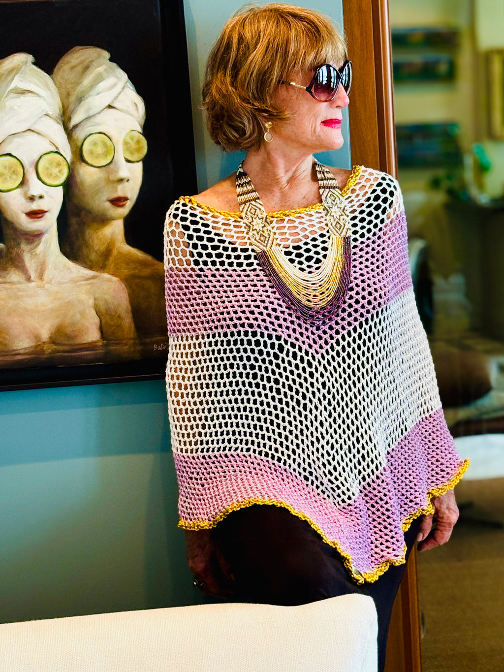 Elegant white poncho with soft rose tones for refined style