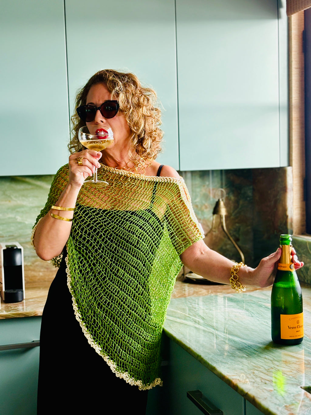 Handmade green crochet asymmetrical poncho worn by model