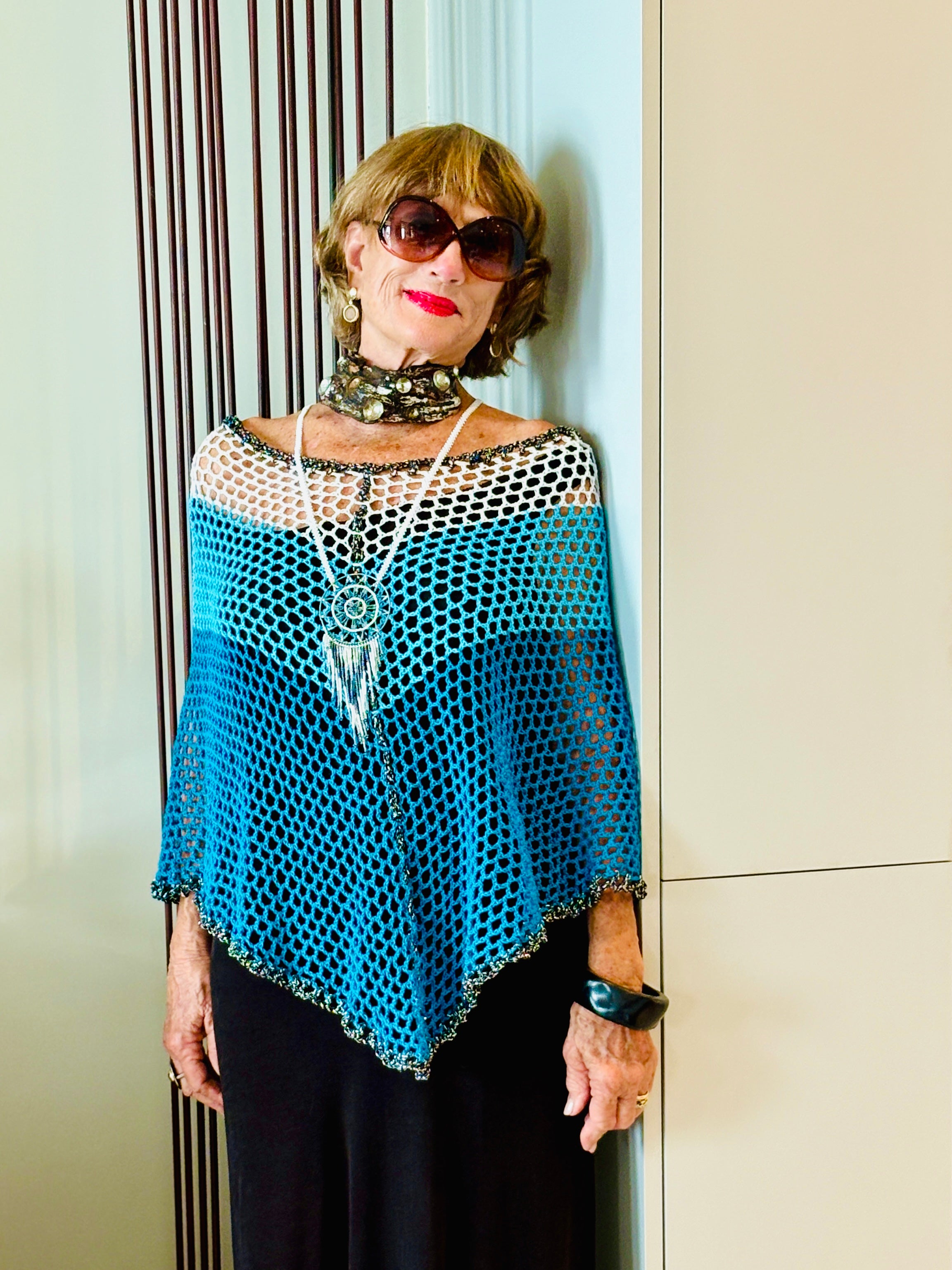 Model wearing Stillwater poncho by Vega Fashion standing indoors