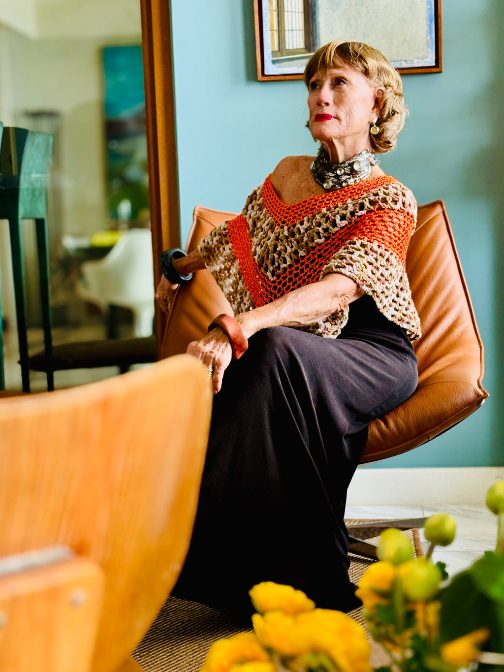 Tiger series orange poncho by Vega Fashion worn by model sitting