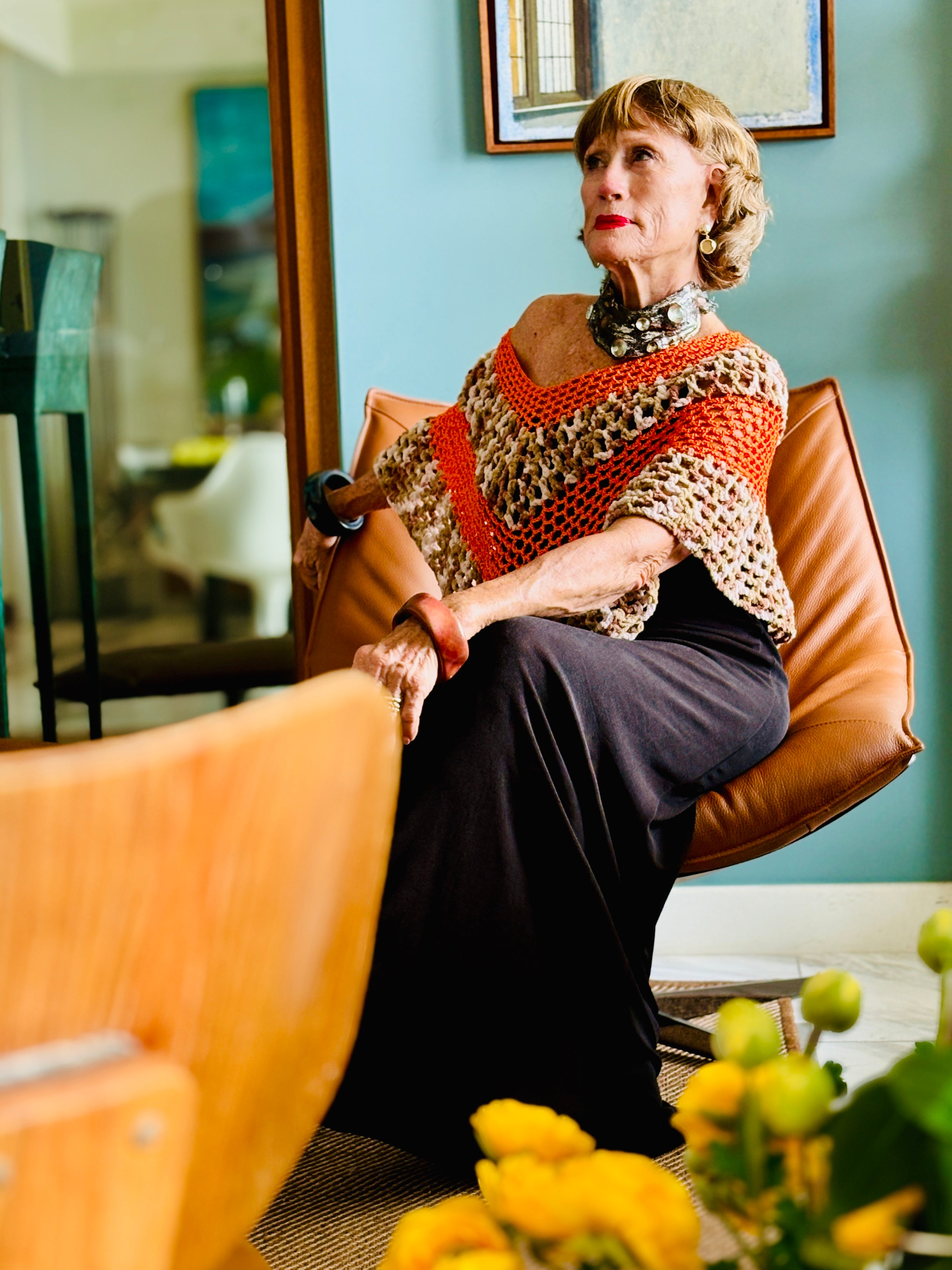 Tiger series orange poncho by Vega Fashion worn by model sitting