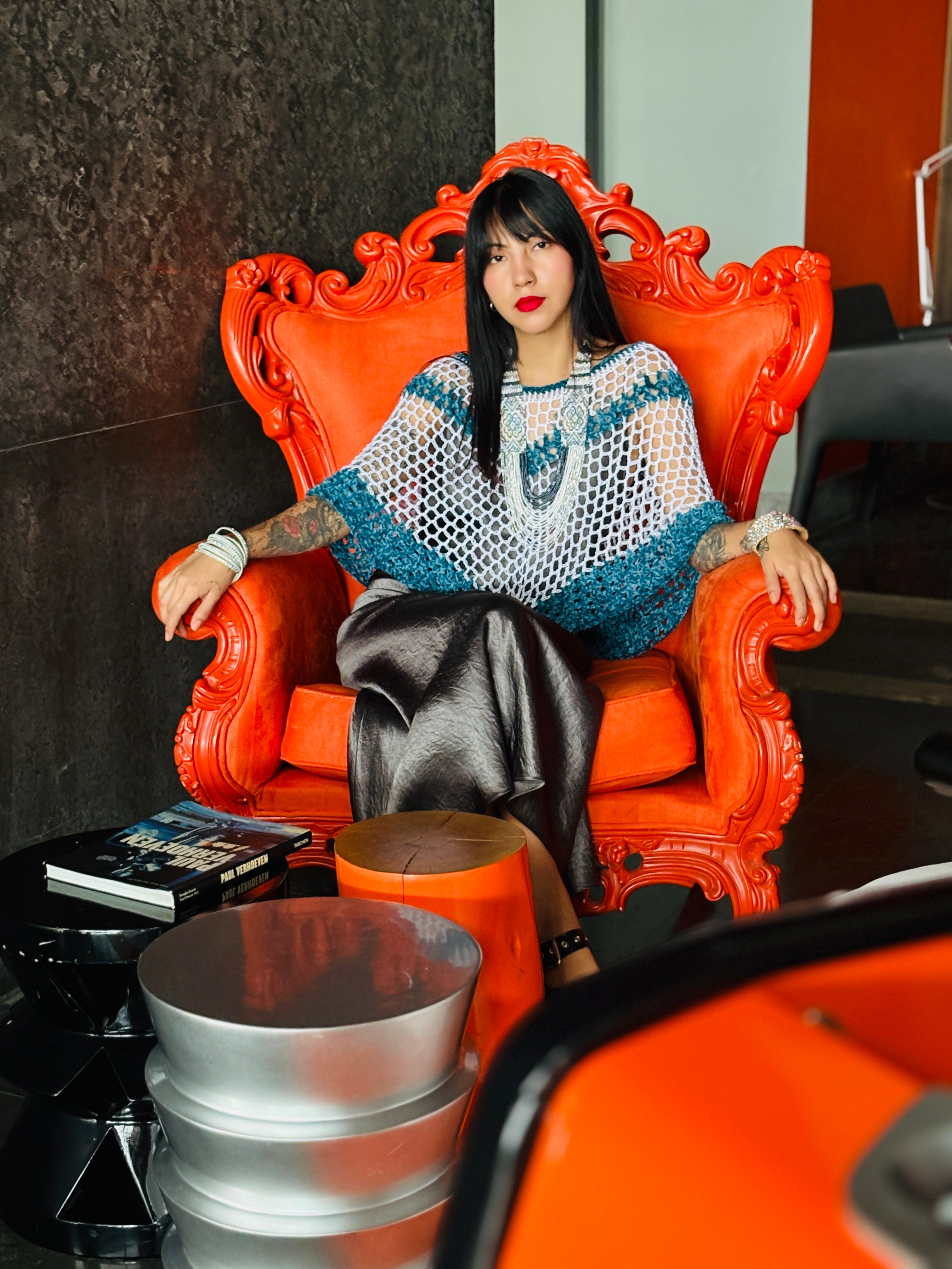 Model sitting on chair wearing blue velvet series handmade poncho