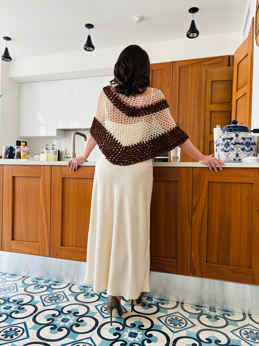 Back view of brown and white velvet poncho showcasing crochet pattern and drape