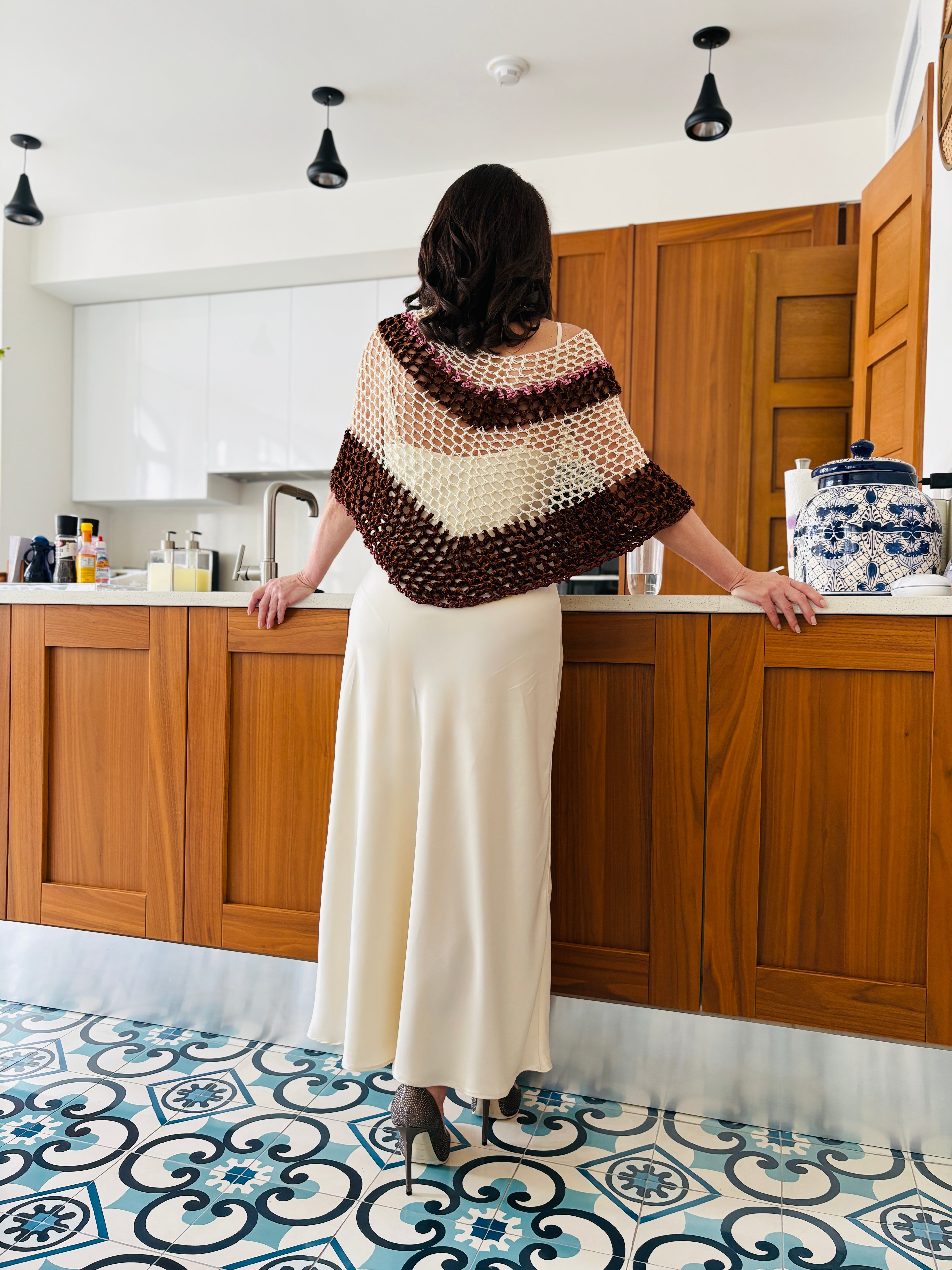 Back view of brown and white velvet poncho showcasing crochet pattern and drape