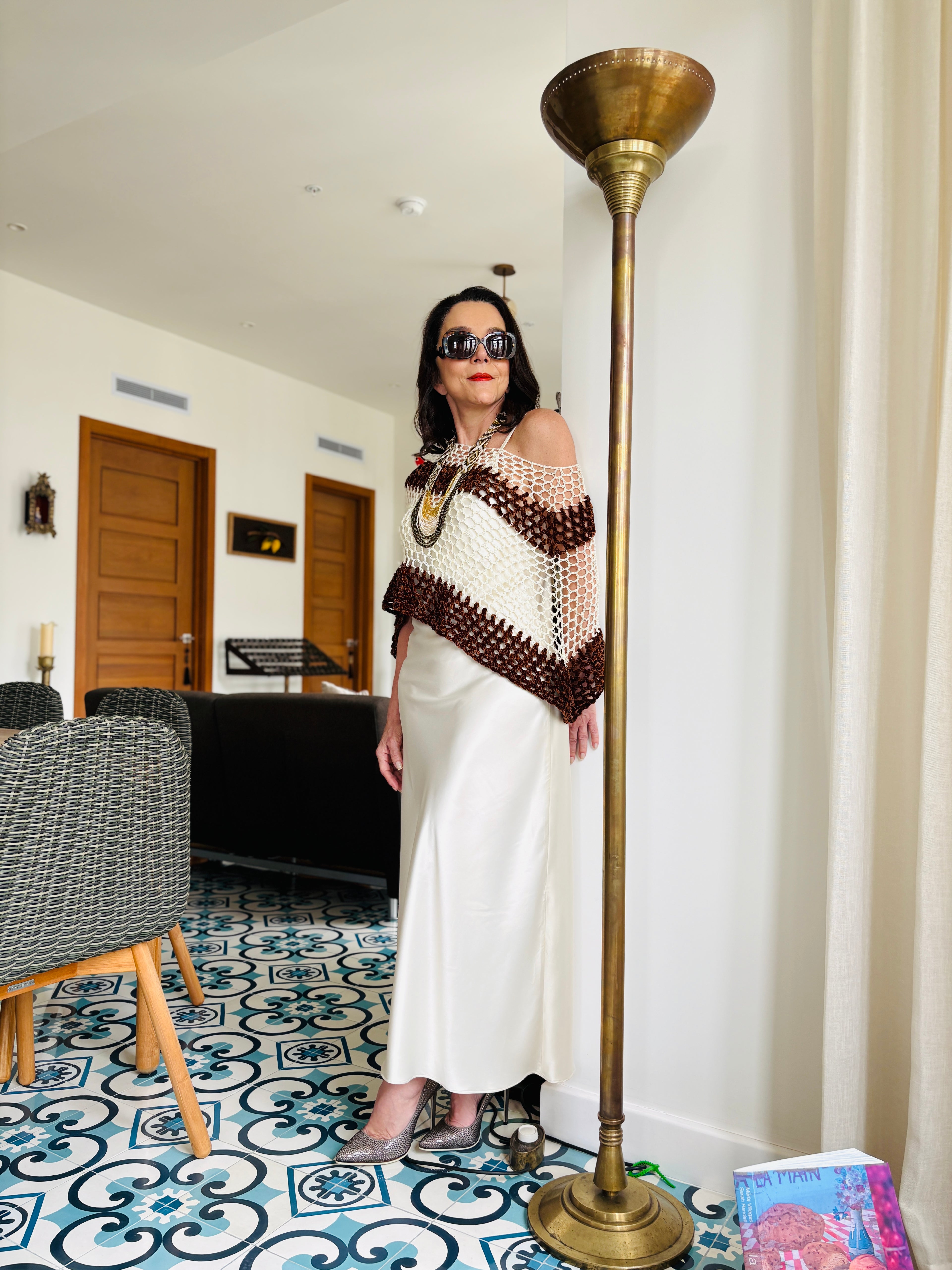 Woman wearing brown and white velvet poncho styled in a modern interior with luxury ambiance