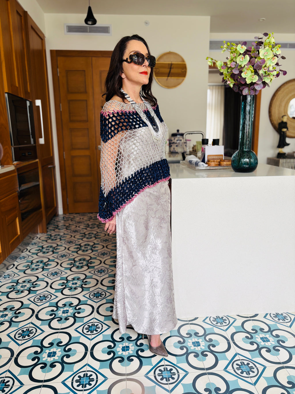 Front view of navy grey velvet poncho paired with long skirt in a refined minimalist look